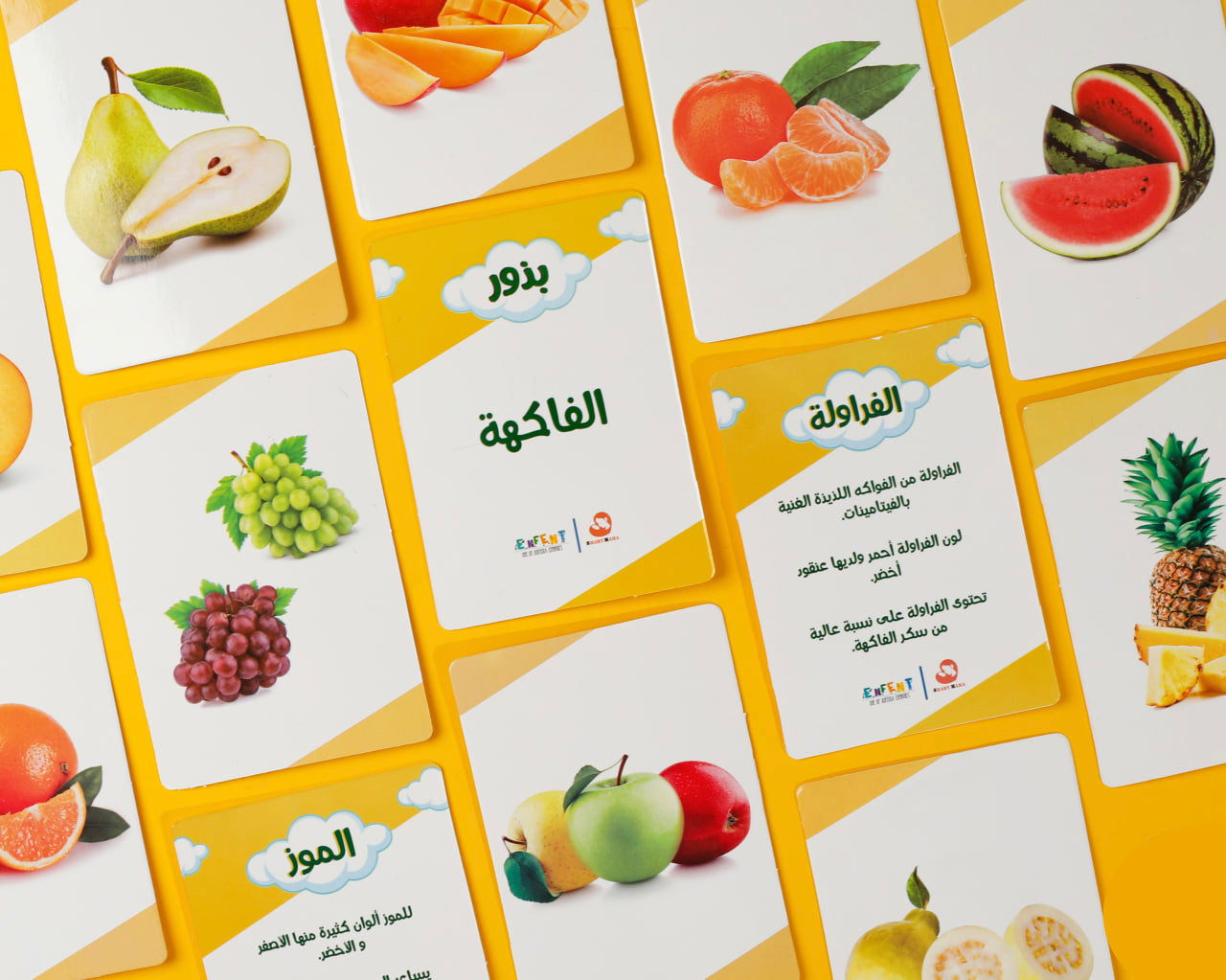 Educational card game with fruits and Arabic text on a yellow background